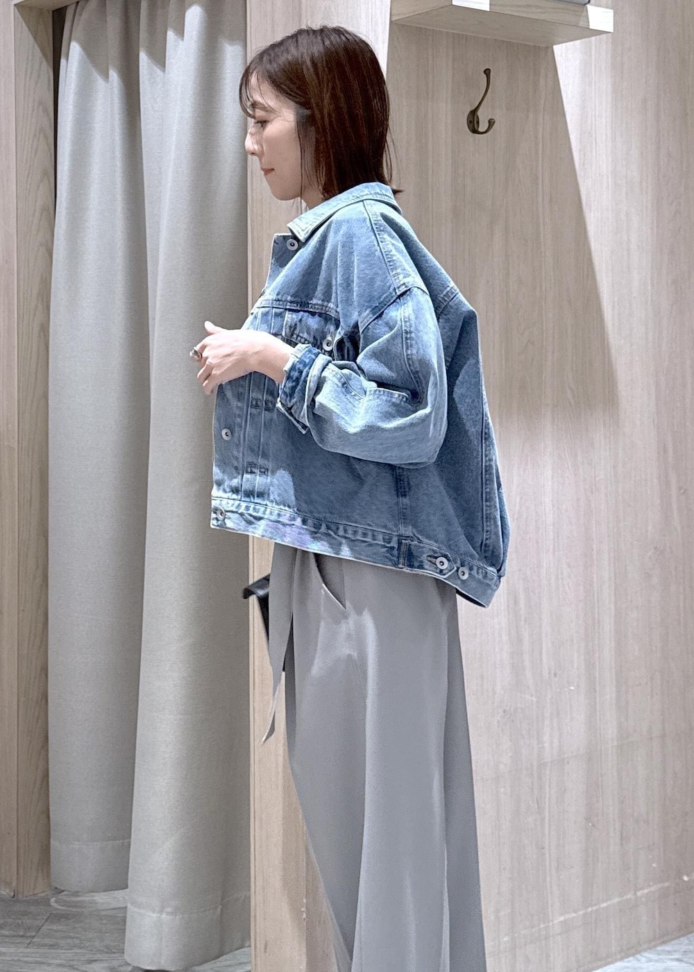 ブラック系のショルダーバッグ、ブルー系のデニムジャケット、グレー系のスラックスを着用したレディースの春コーディネートの9枚目の写真