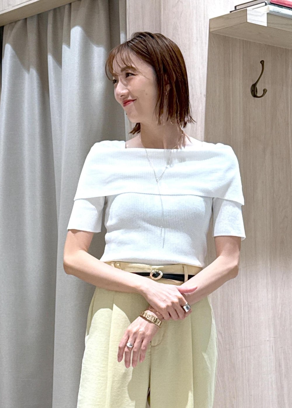 ブルー系のハンドバッグ、ブラック系のサンダル、イエロー系のスラックスを着用したレディースの夏コーディネートの8枚目の写真