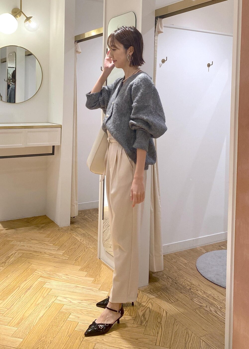 ホワイト系のトートバッグ、ブラック系のパンプス、ベージュ系のその他パンツを着用したレディースの冬コーディネートの4枚目の写真