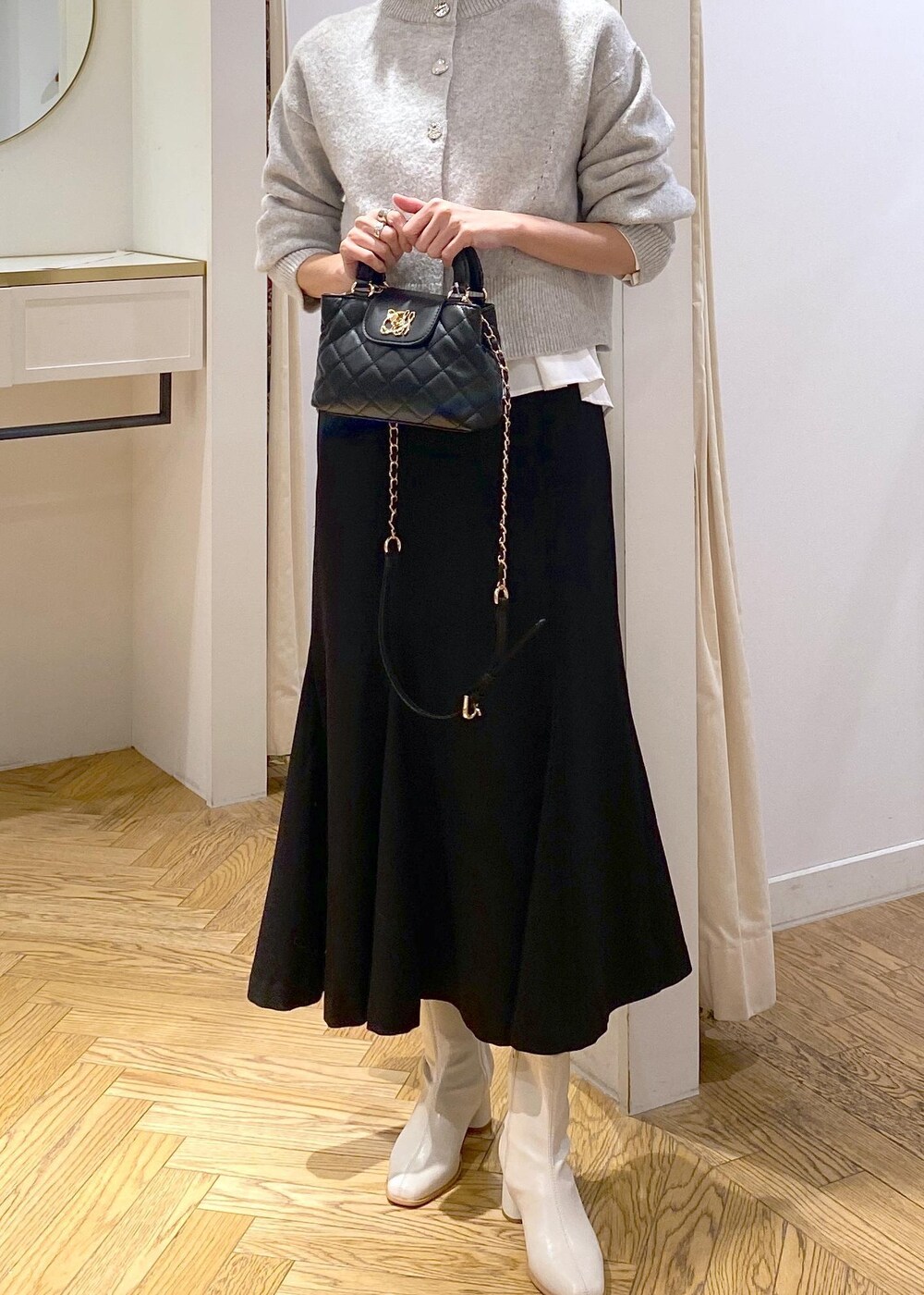 ホワイト系のシャツ/ブラウス、グレー系のカーディガン/ボレロ、ホワイト系のブーツを着用したレディースの冬コーディネートの6枚目の写真