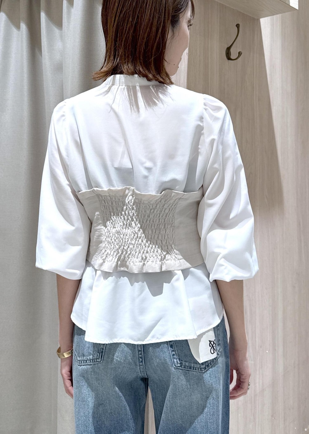 イエロー系のショルダーバッグ、ピンク系のナイロンジャケット、ブルー系のデニムパンツを着用したレディースの春コーディネートの10枚目の写真