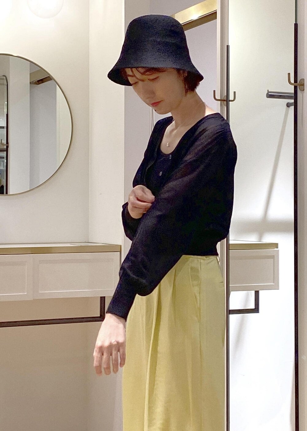 ブラック系のキャミソール、イエロー系のスラックス、ブラック系のショルダーバッグを着用したレディースの夏コーディネートの5枚目の写真