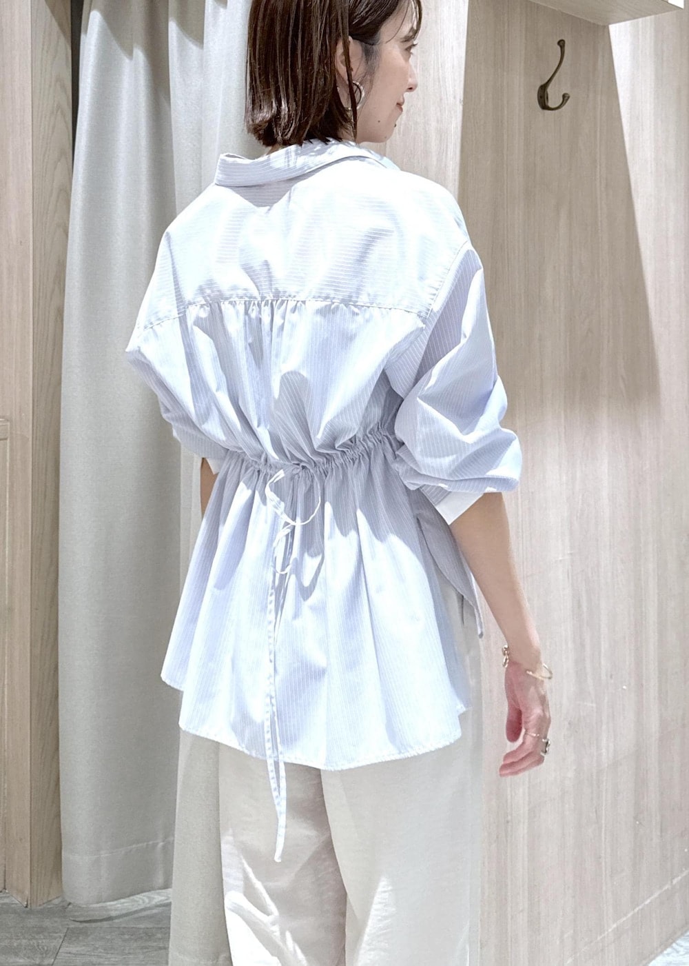 ベージュ系のキャミソール、ブラック系のショルダーバッグ、ブルー系のシャツ/ブラウスを着用したレディースの春コーディネートの6枚目の写真