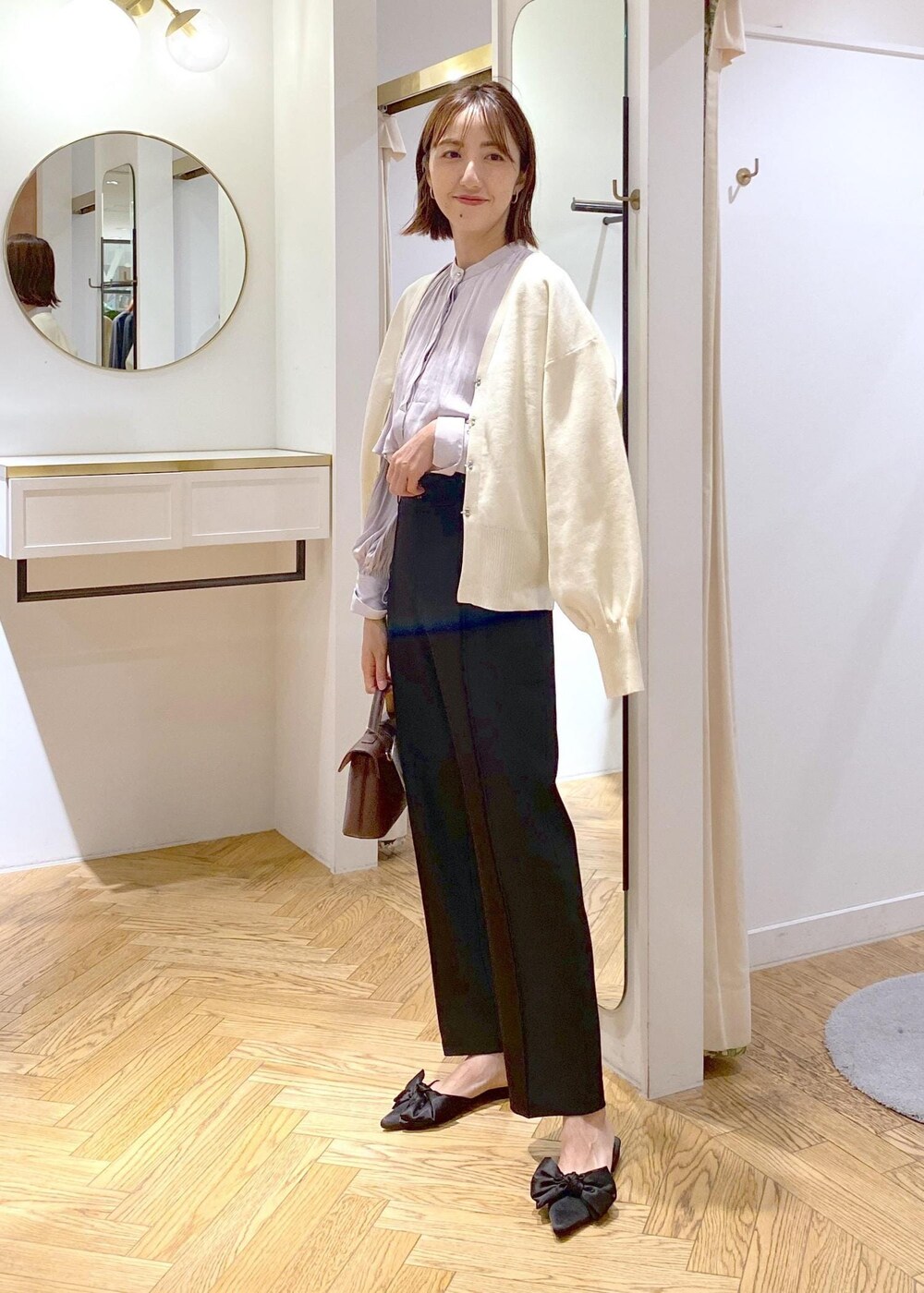 ブラウン系のショルダーバッグ、ブラック系のサンダル、ブラック系のスラックスを着用したレディースの秋コーディネートの10枚目の写真