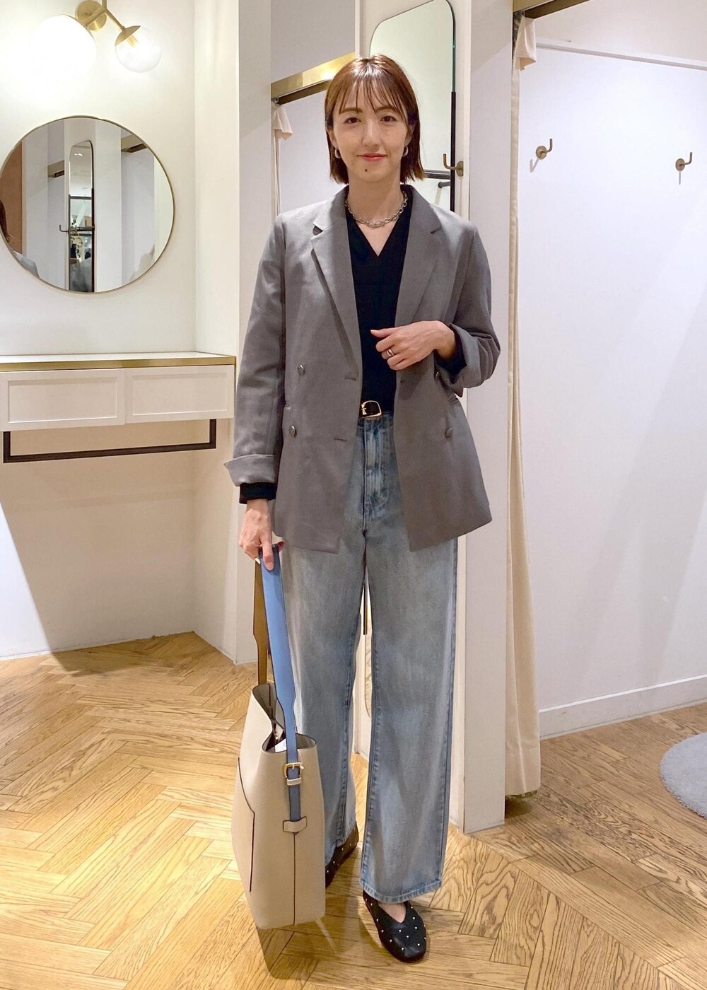 ベージュ系のショルダーバッグ、ブラック系のバレエシューズ、グレー系のテーラードジャケットを着用したレディースの秋コーディネートの3枚目の写真
