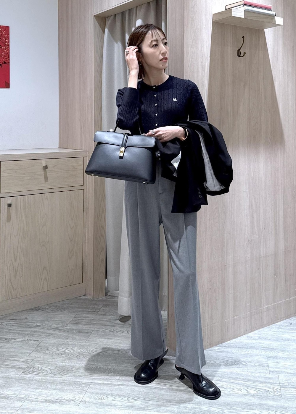 ブラック系のハンドバッグ、ブラック系のテーラードジャケット、グレー系のその他パンツを着用したレディースの冬コーディネートの9枚目の写真
