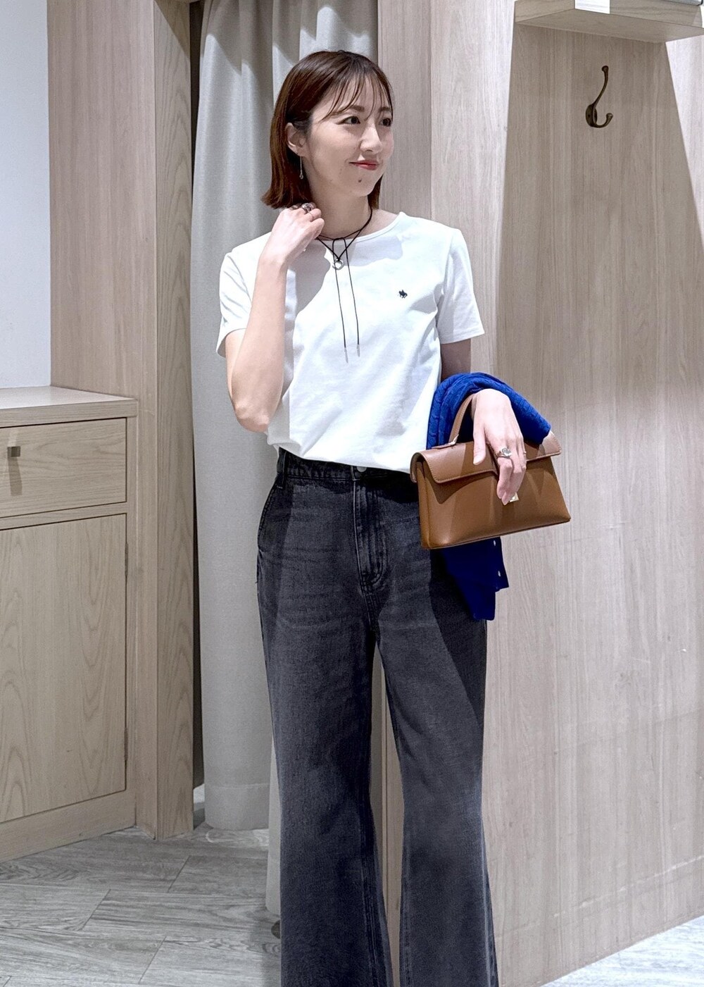 イエロー系のショルダーバッグ、ブラック系のデニムパンツ、ホワイト系のTシャツ/カットソーを着用したレディースの春コーディネートの2枚目の写真