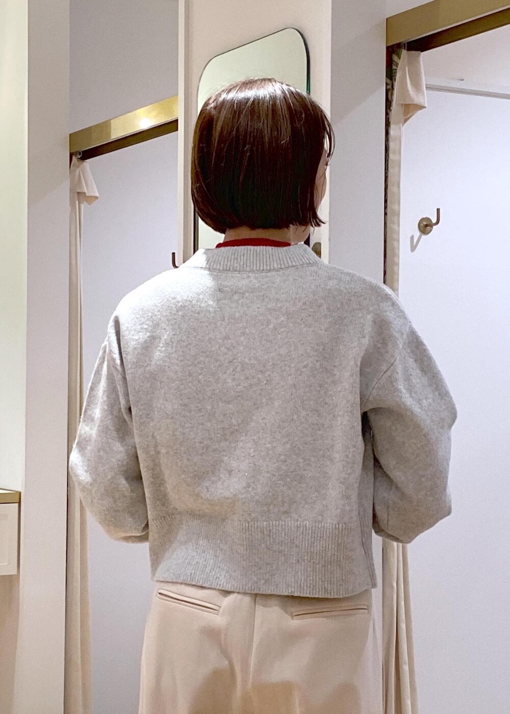 ホワイト系のブーツ、グレー系のカーディガン/ボレロ、レッド系のニット/セーターを着用したレディースの冬コーディネートの9枚目の写真