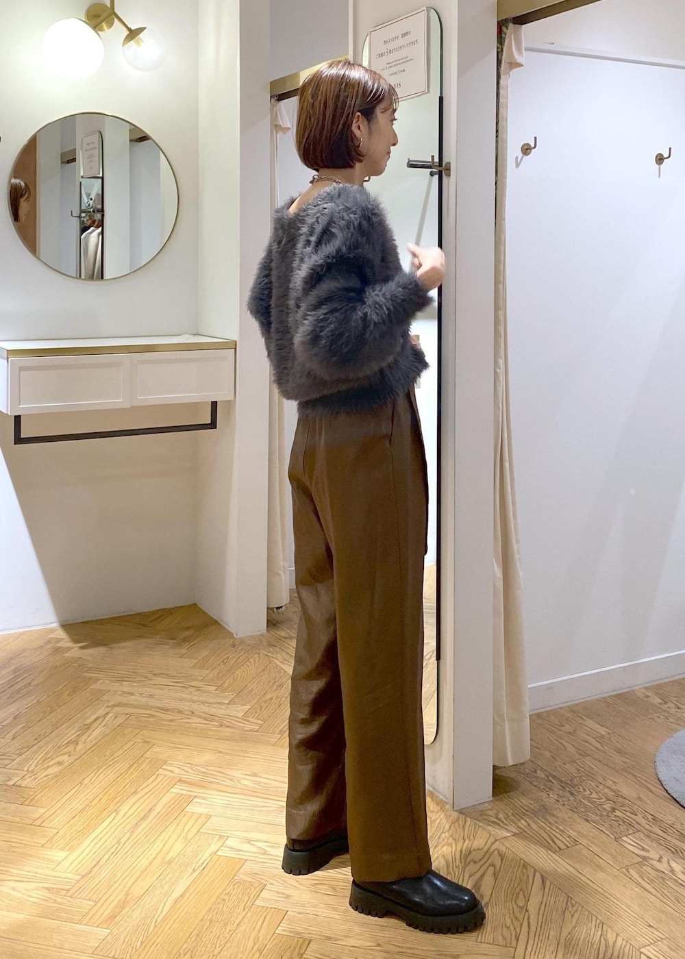 ブラック系のショルダーバッグ、ブラック系のブーツ、グレー系のカーディガン/ボレロを着用したレディースの冬コーディネートの3枚目の写真