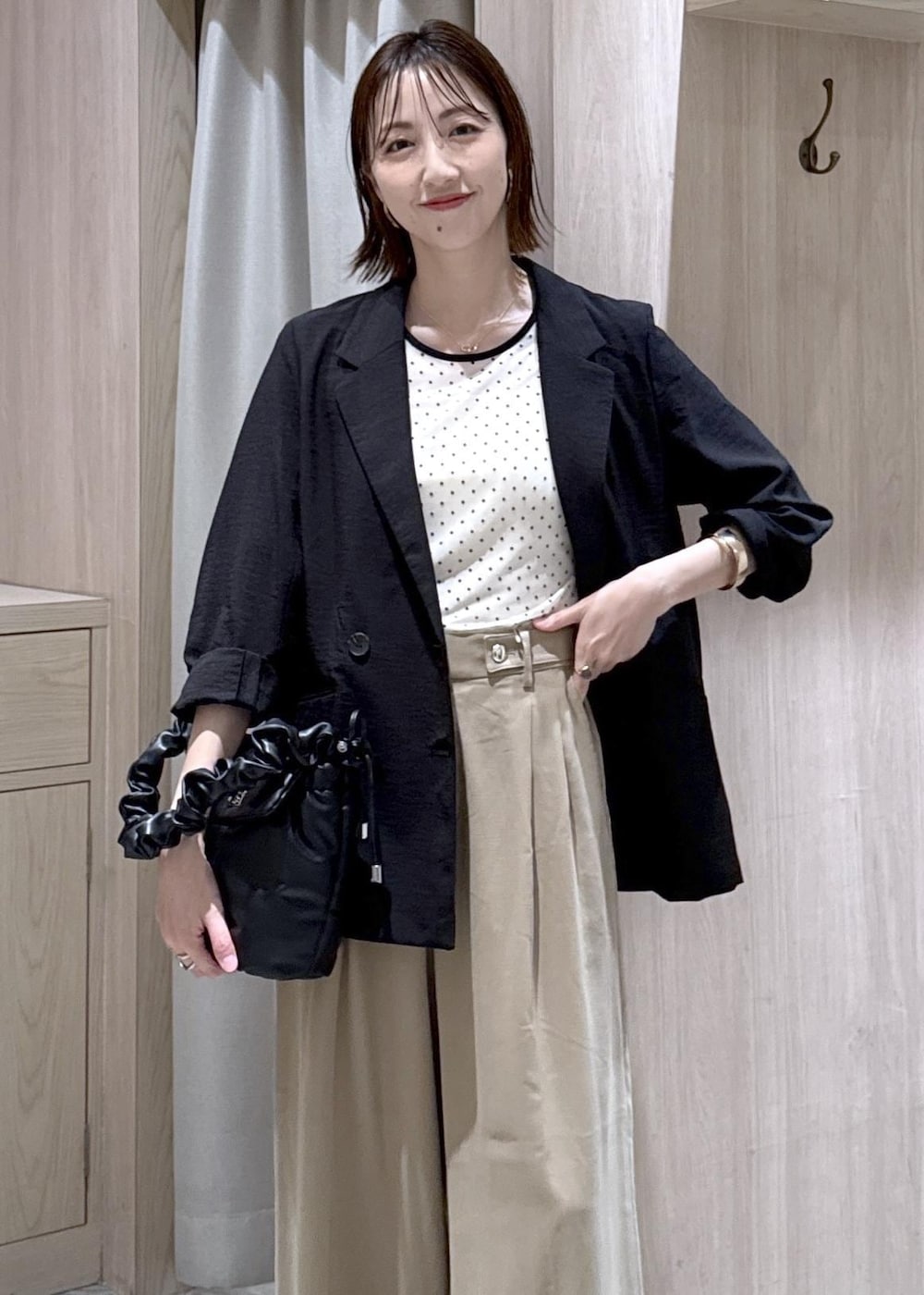 ベージュ系のその他パンツ、ブラック系のテーラードジャケット、ブラック系のショルダーバッグを着用したレディースの春コーディネートの3枚目の写真