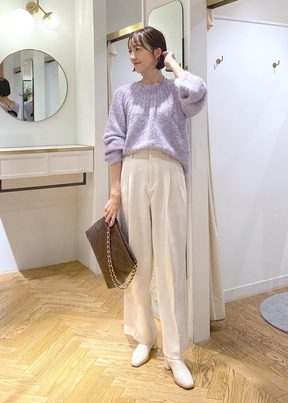 ホワイト系のブーツ、ブラック系のショルダーバッグ、パープル系のニット/セーターを着用したレディースの冬コーディネートの4枚目の写真