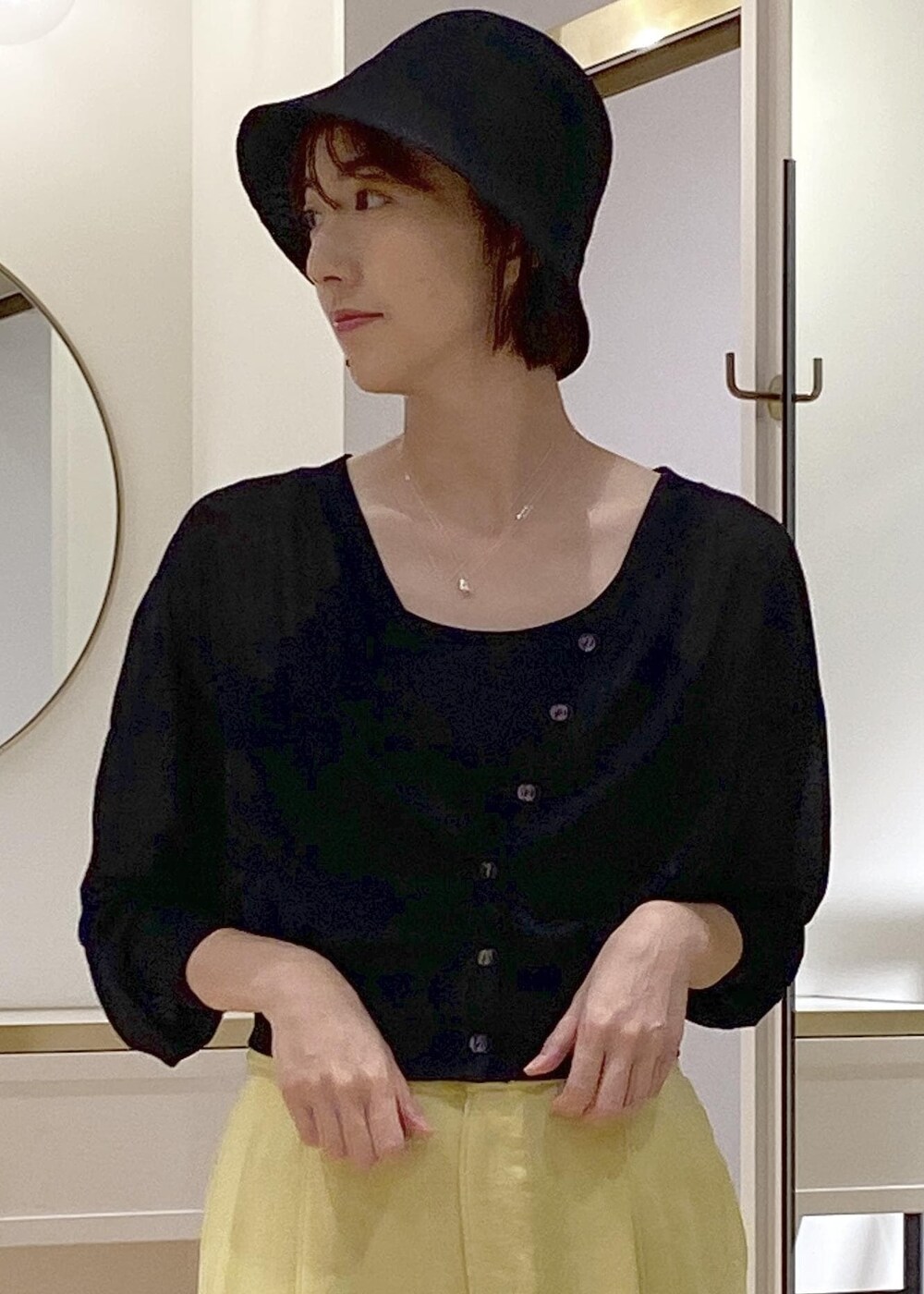 ブラック系のキャミソール、イエロー系のスラックス、ブラック系のショルダーバッグを着用したレディースの夏コーディネートの6枚目の写真