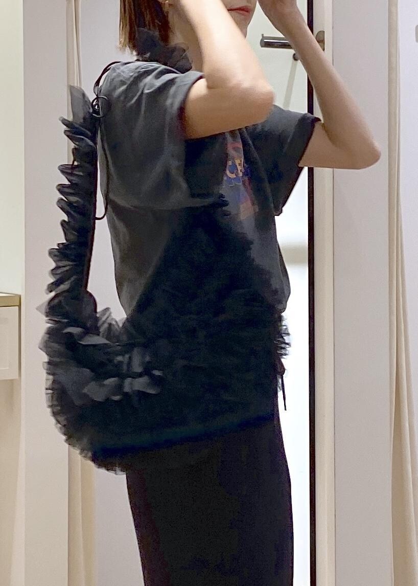 ブラック系のショルダーバッグ、ブラック系のスカート、グレー系のTシャツ/カットソーを着用したレディースの夏コーディネートの5枚目の写真