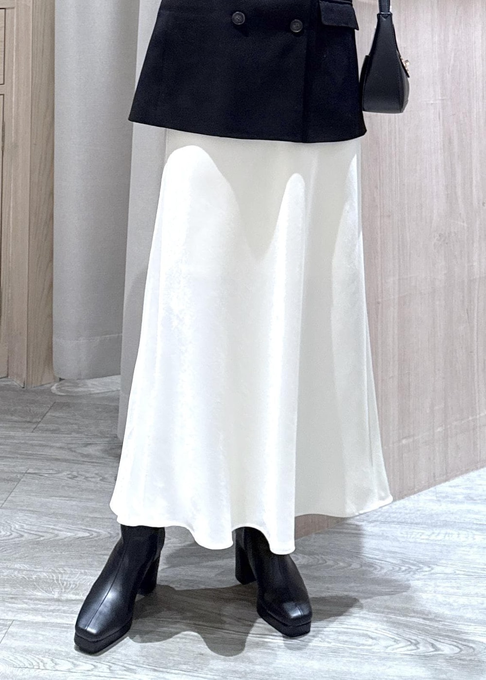 ブラック系のショルダーバッグ、ブラック系のテーラードジャケット、ブラック系のブーツを着用したレディースの冬コーディネートの5枚目の写真