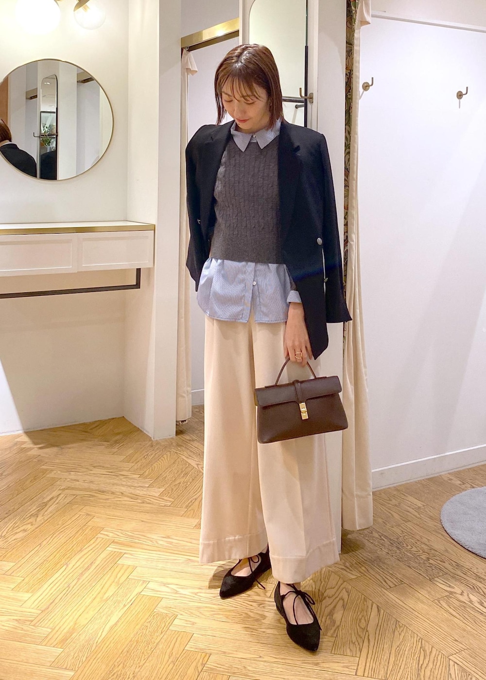 ブラウン系のショルダーバッグ、ブラック系のテーラードジャケット、ブルー系のシャツ/ブラウスを着用したレディースの冬コーディネートの2枚目の写真