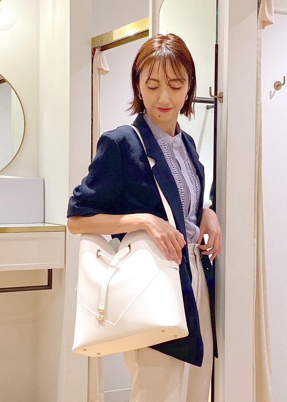 ブルー系のテーラードジャケット、ブルー系のシャツ/ブラウス、ホワイト系のスラックスを着用したレディースの夏コーディネートの3枚目の写真