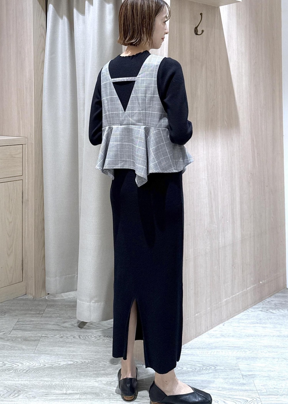 グレー系のテーラードジャケット、ブラック系のショルダーバッグ、ブラック系のワンピースを着用したレディースの冬コーディネートの6枚目の写真