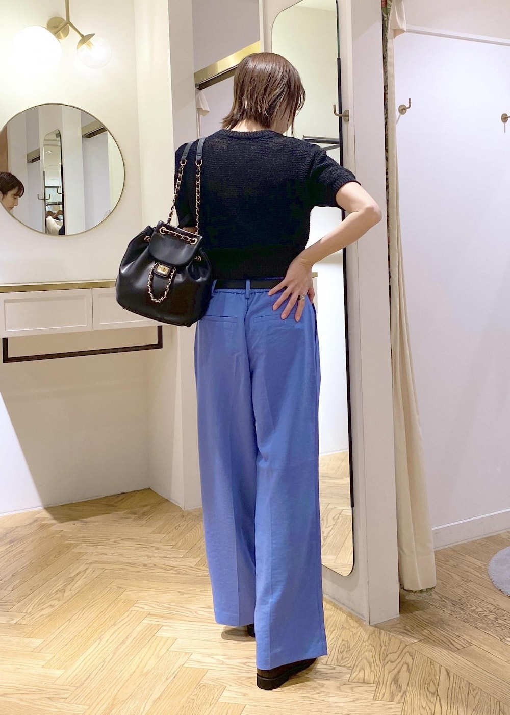 ブラック系のローファー、ブルー系のスラックス、ブラック系のバックパック/リュックを着用したレディースの春コーディネートの2枚目の写真