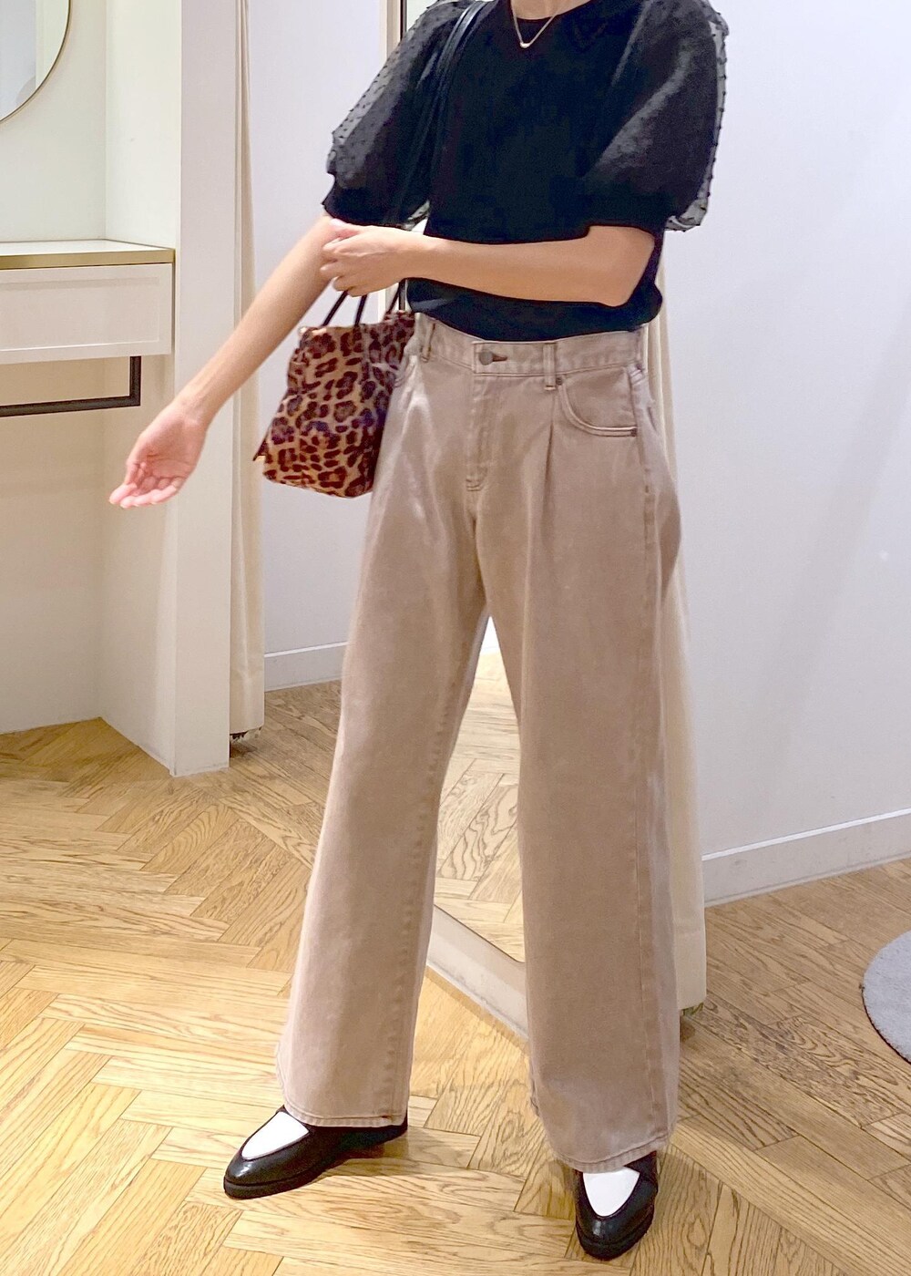 ブラック系のローファー、ブラック系のニット/セーター、ブラウン系のデニムパンツを着用したレディースの夏コーディネートの5枚目の写真