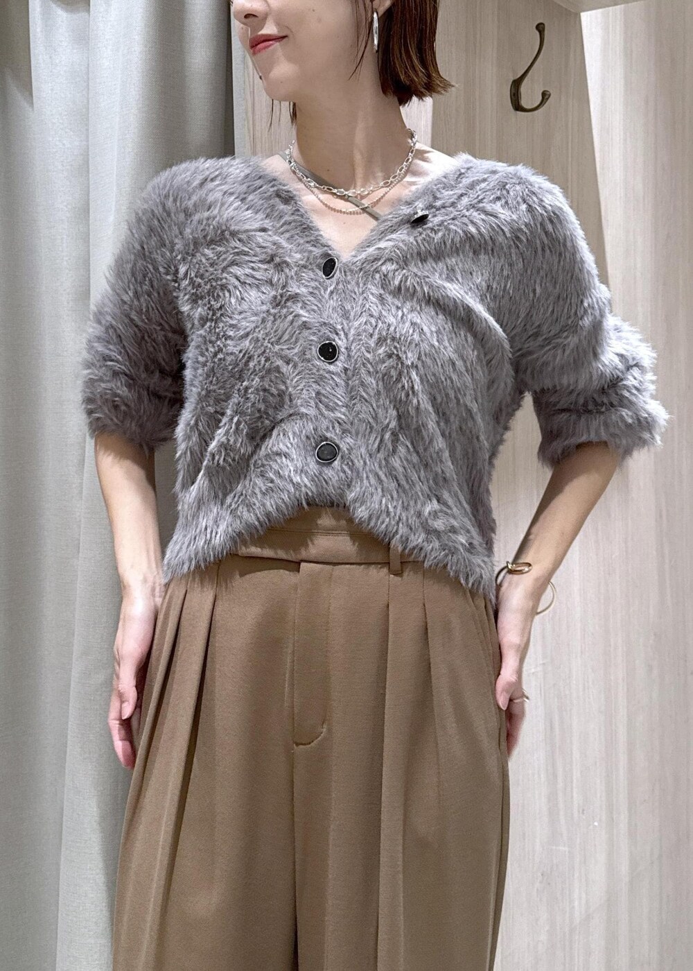 ブラック系のショルダーバッグ、グレー系のカーディガン/ボレロ、ブラック系のブーツを着用したレディースの秋コーディネートの8枚目の写真