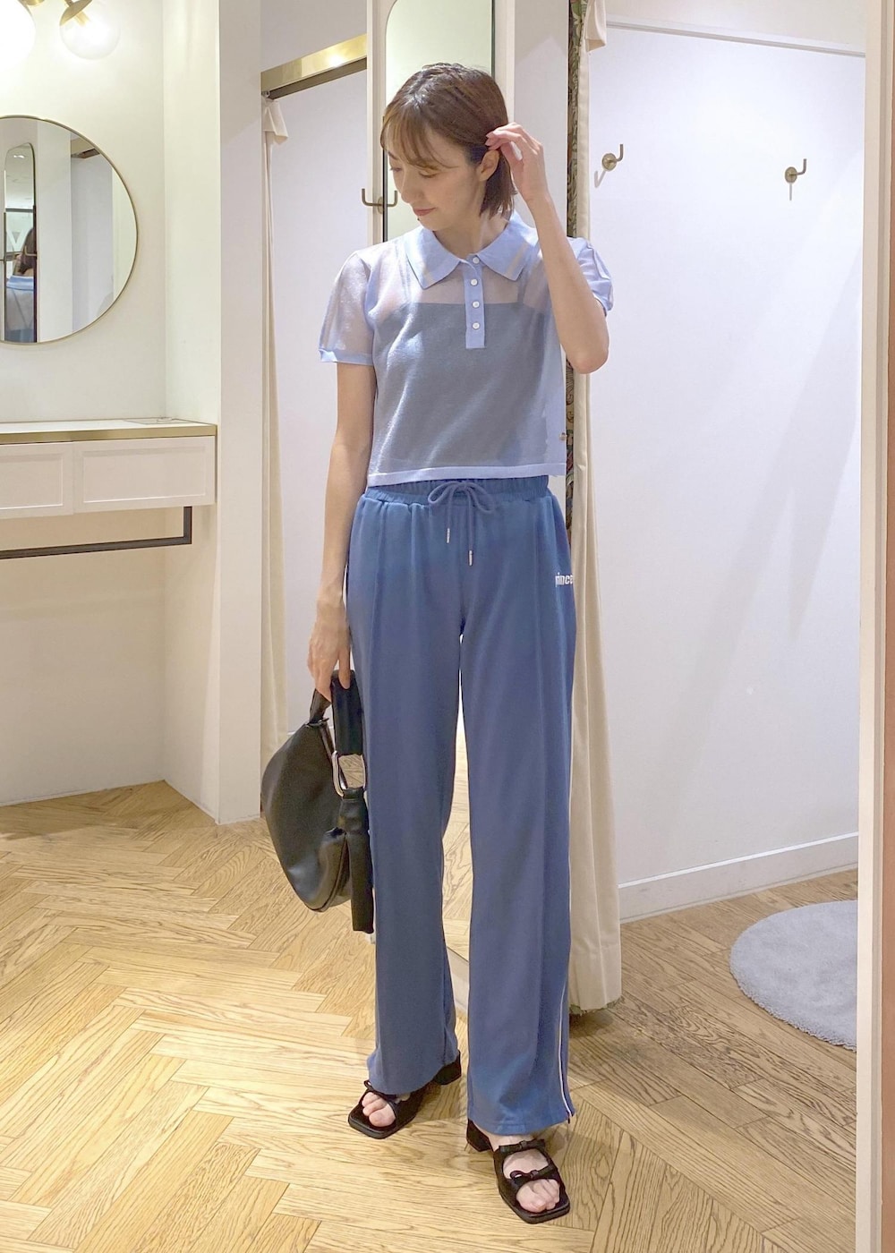 ブラック系のハンドバッグ、ブラック系のサンダル、ブラック系のキャミソールを着用したレディースの夏コーディネートの2枚目の写真