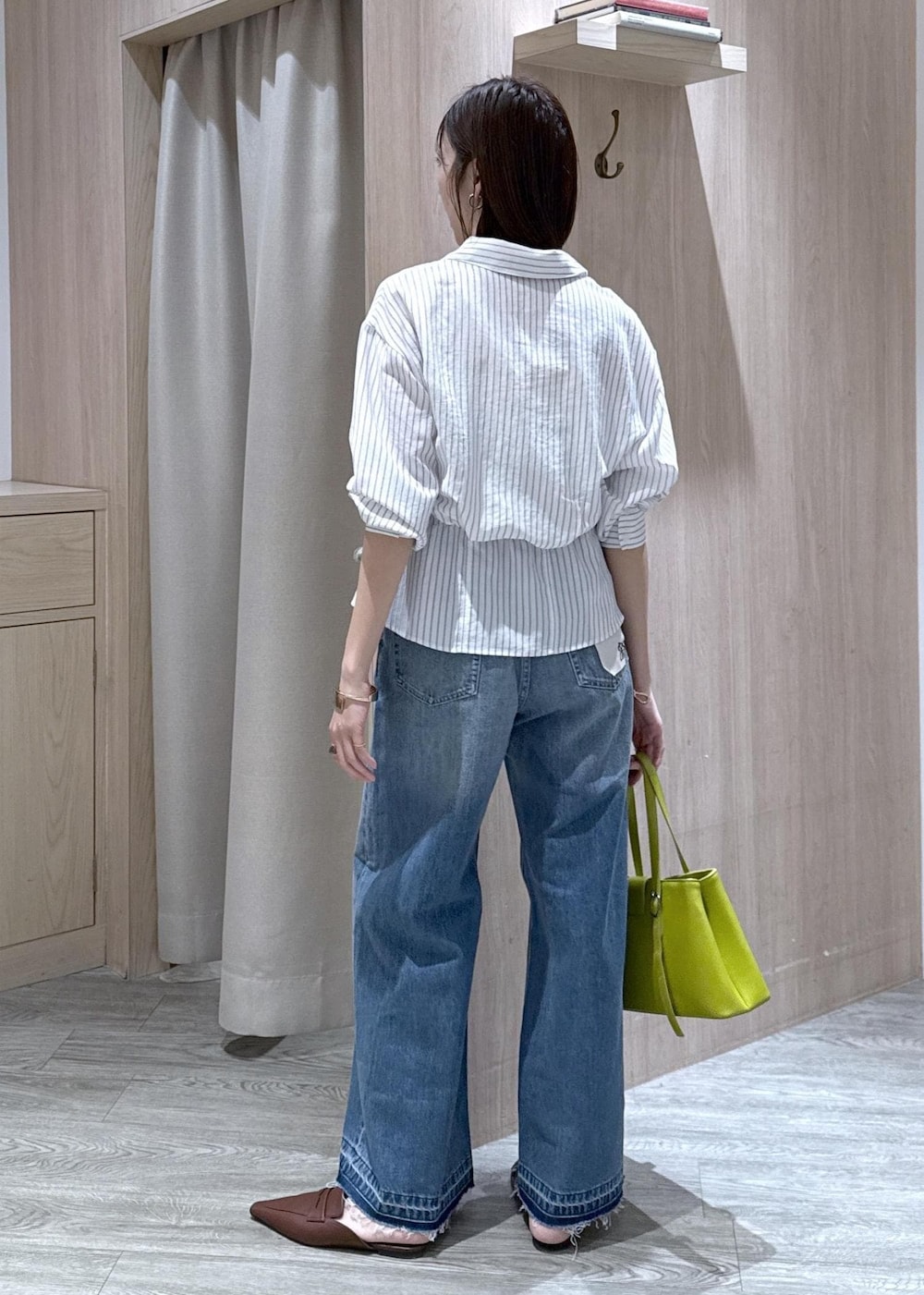 ブルー系のデニムパンツ、グリーン系のトートバッグ、ホワイト系のシャツ/ブラウスを着用したレディースの春コーディネートの4枚目の写真