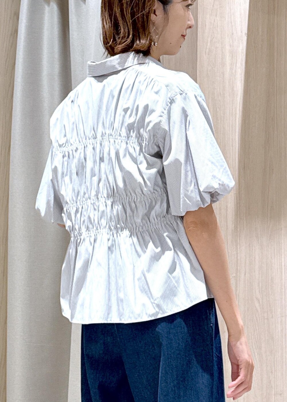 ブラック系のショルダーバッグ、ブラック系のサンダル、ブルー系のデニムパンツを着用したレディースの夏コーディネートの10枚目の写真