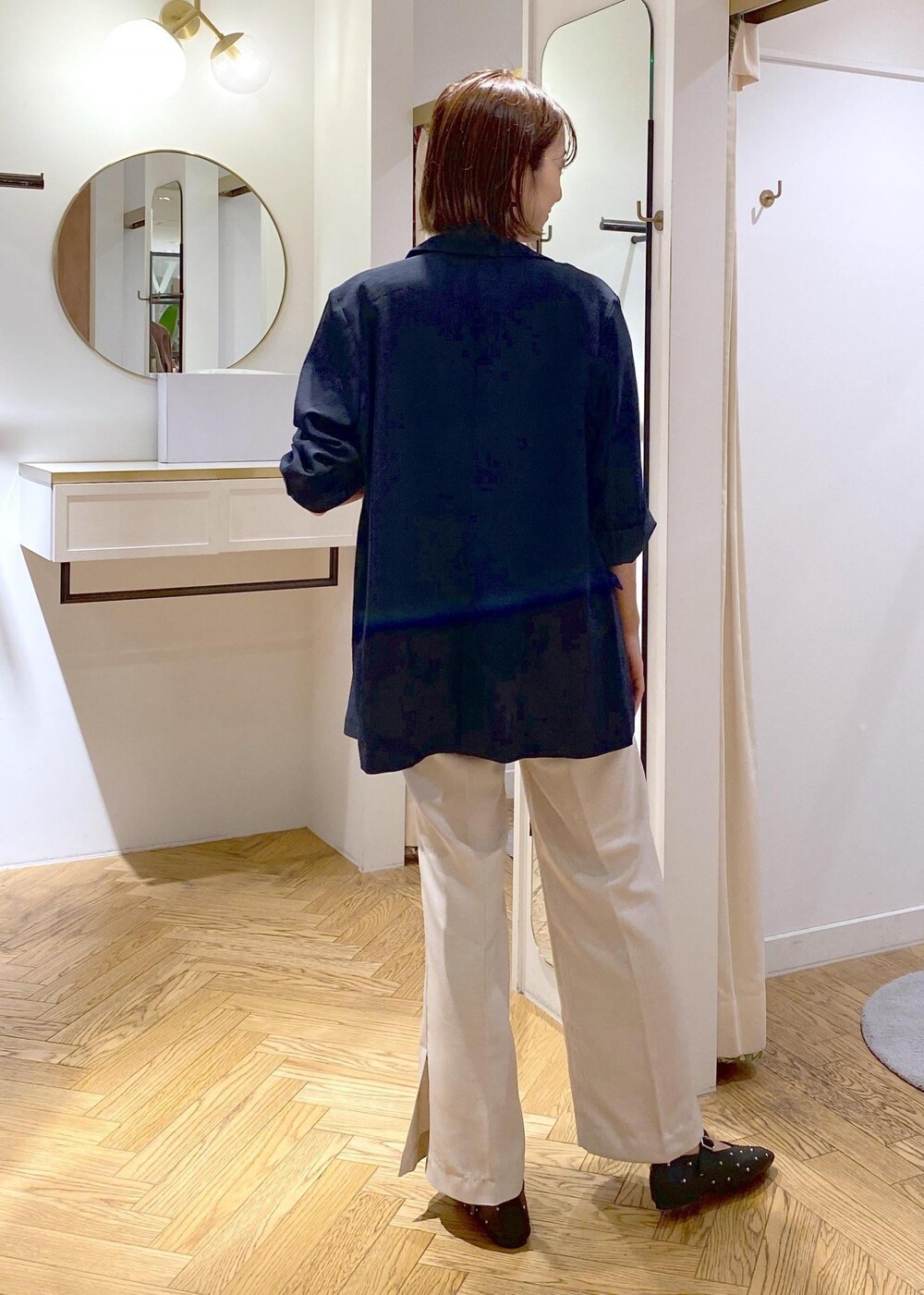 ブルー系のテーラードジャケット、ブルー系のシャツ/ブラウス、ホワイト系のスラックスを着用したレディースの夏コーディネートの6枚目の写真