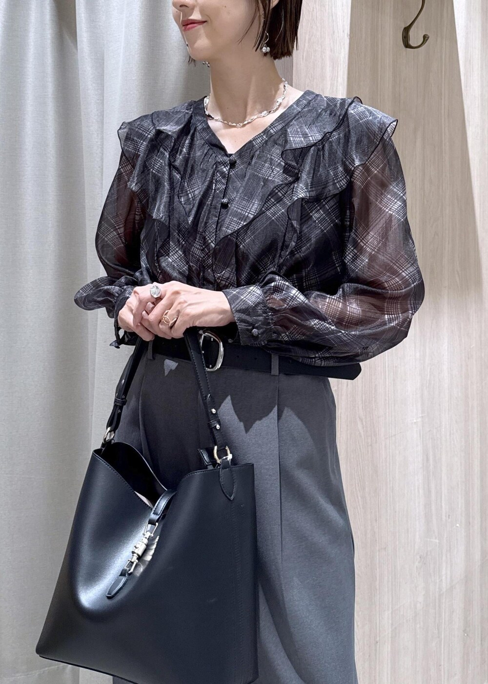 ブラック系のトートバッグ、ブラック系のローファー、ブラック系のシャツ/ブラウスを着用したレディースの秋コーディネートの6枚目の写真