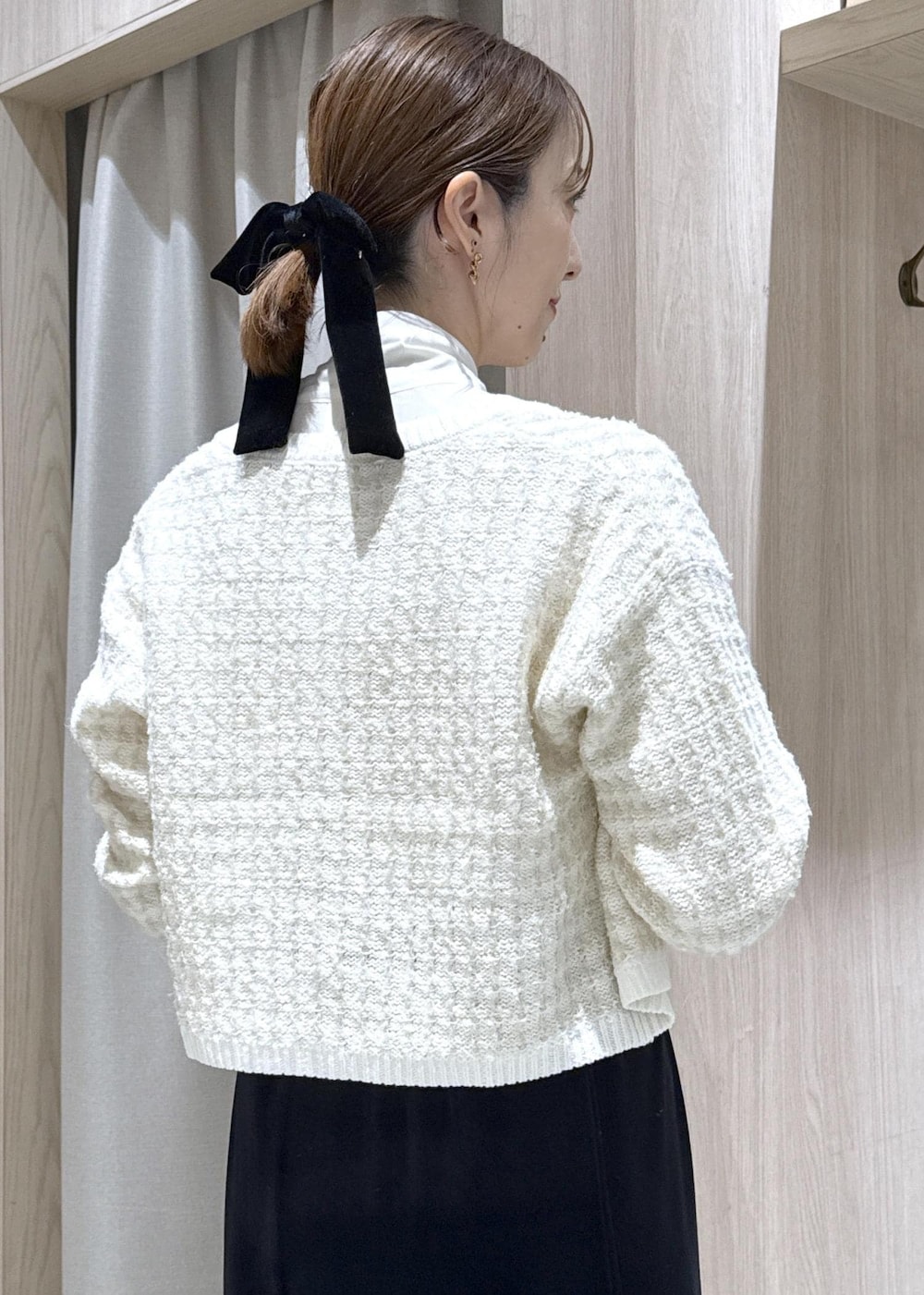 ブラック系のパンプス、ホワイト系のカーディガン/ボレロ、ブラック系のショルダーバッグを着用したレディースの秋コーディネートの7枚目の写真