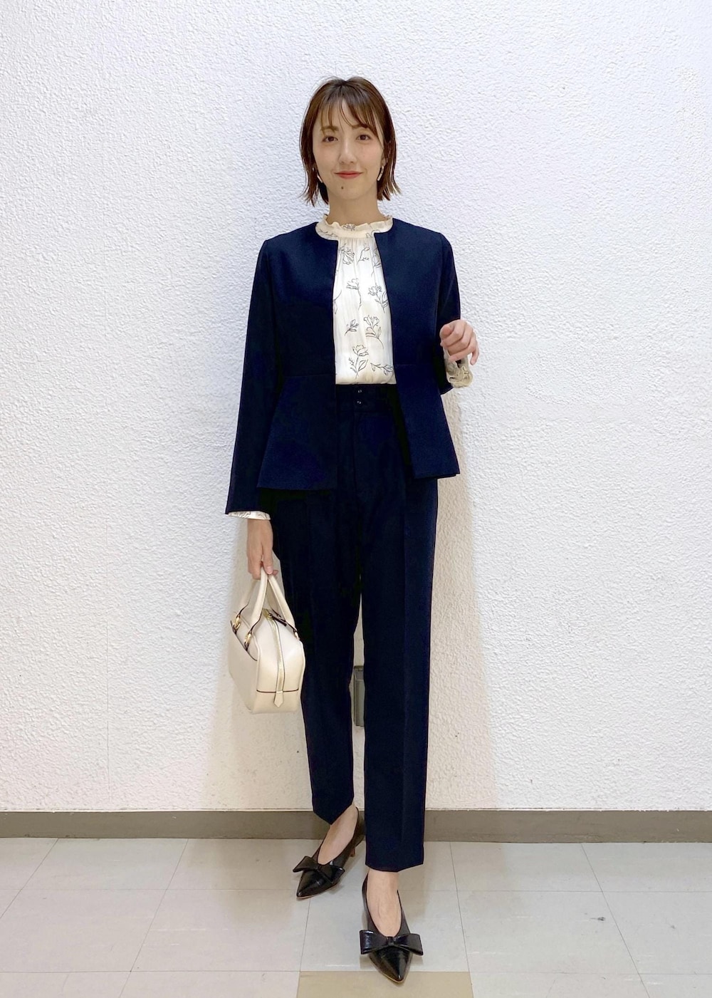 ブラック系のパンプス、ホワイト系のシャツ/ブラウス、ブルー系のスラックスを着用したレディースの冬コーディネートの5枚目の写真