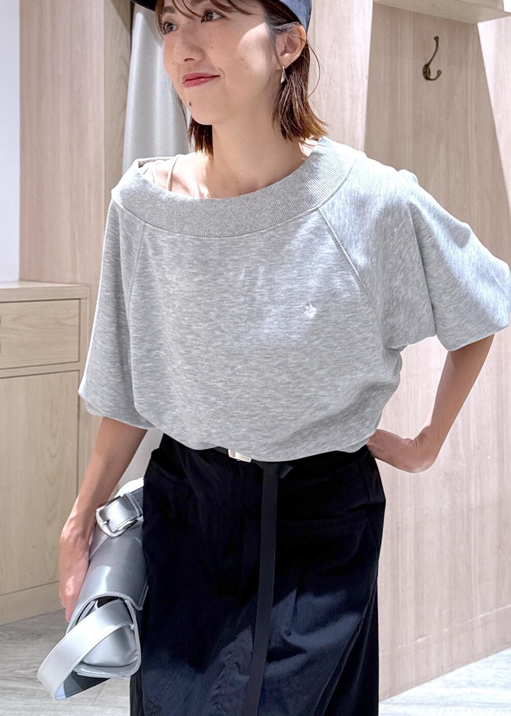 シルバー系のショルダーバッグ、ブラック系のスカート、ホワイト系のキャミソールを着用したレディースの秋コーディネートの8枚目の写真