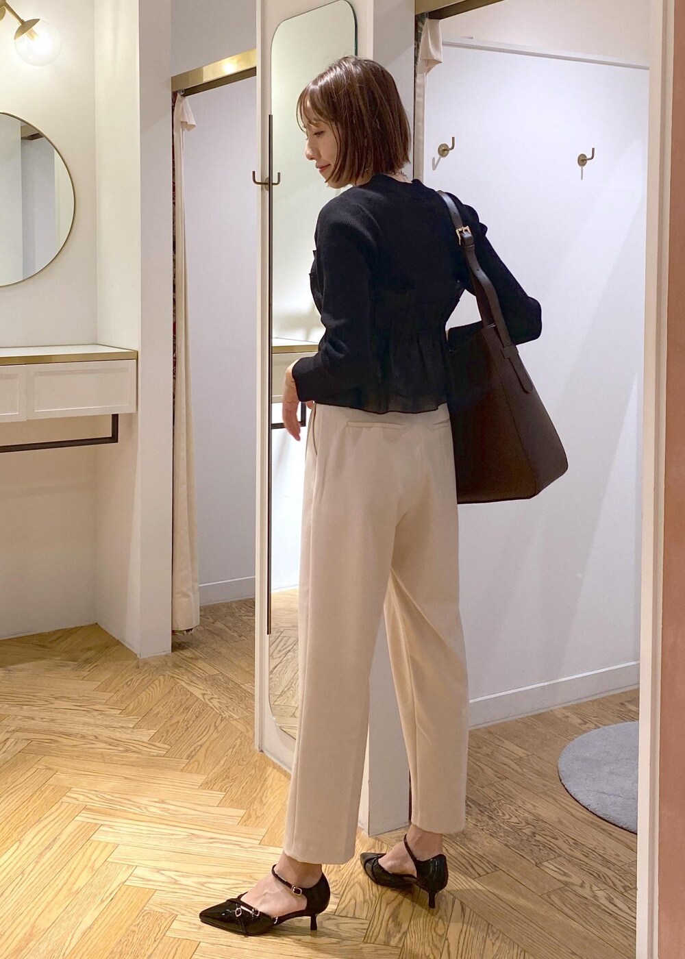 ブラック系のパンプス、ブラック系のニット/セーター、ベージュ系のその他パンツを着用したレディースの冬コーディネートの3枚目の写真