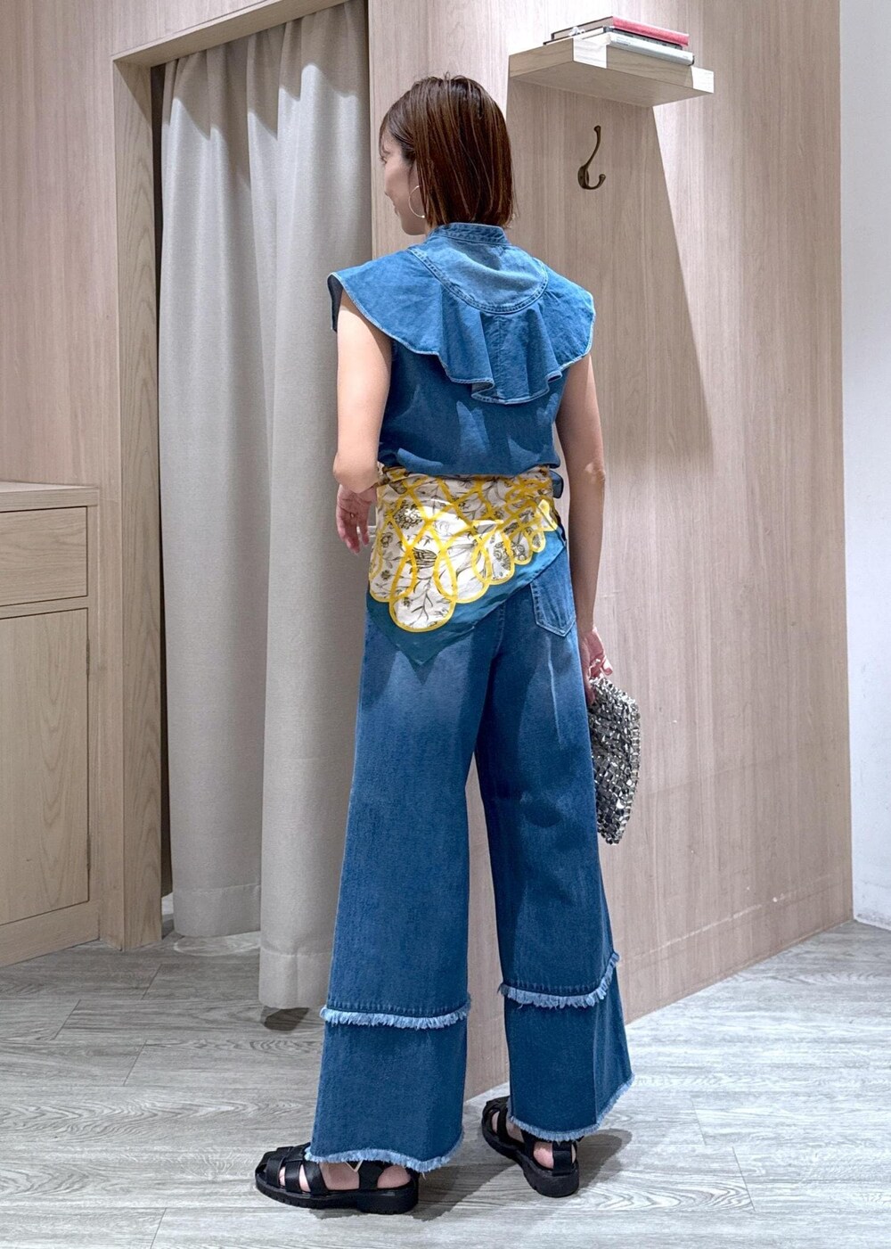 シルバー系のハンドバッグ、ブルー系のシャツ/ブラウス、ブルー系のデニムパンツを着用したレディースの夏コーディネートの4枚目の写真