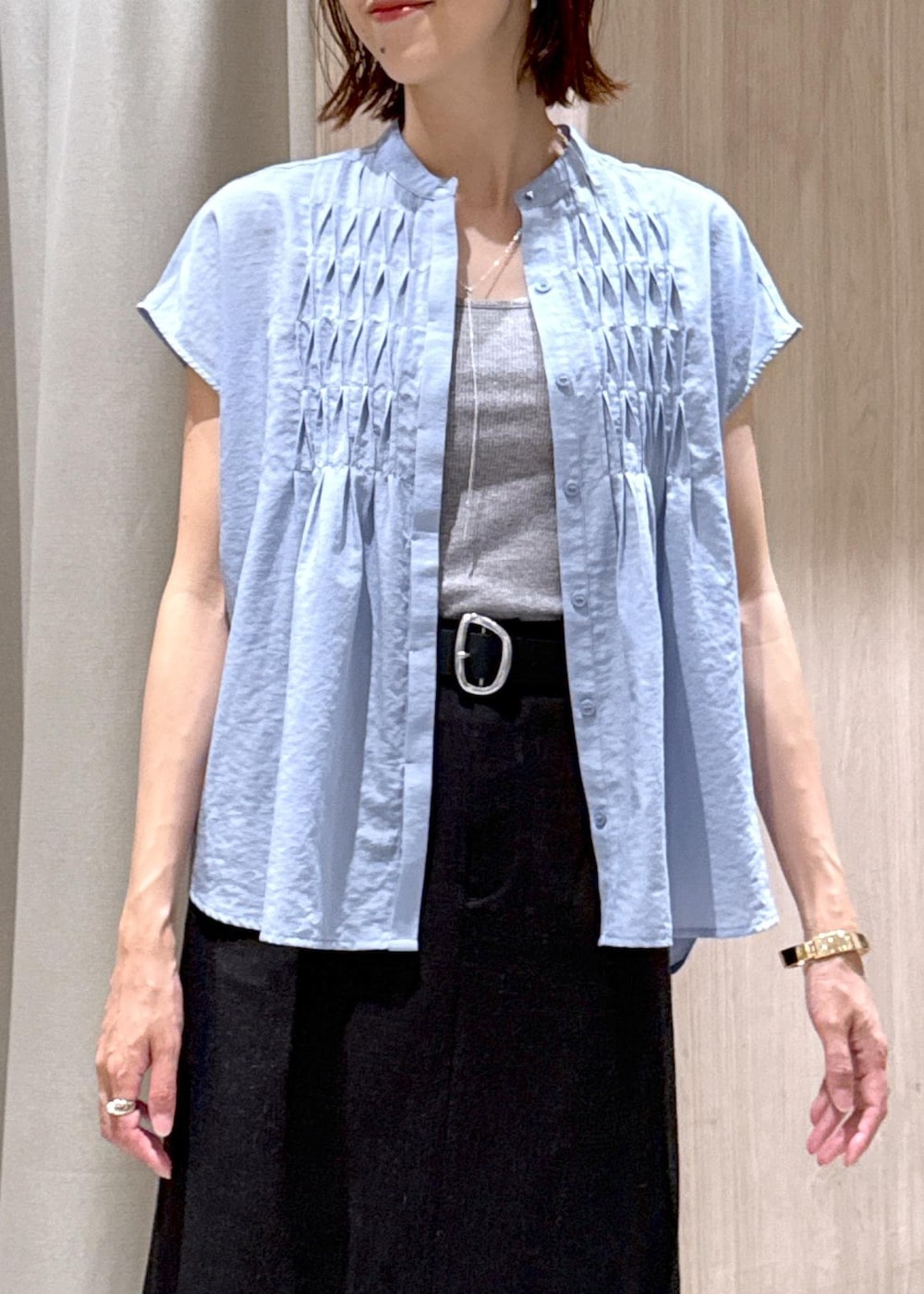 グレー系のタンクトップ、ホワイト系のテーラードジャケット、ブラック系のトートバッグを着用したレディースの夏コーディネートの7枚目の写真