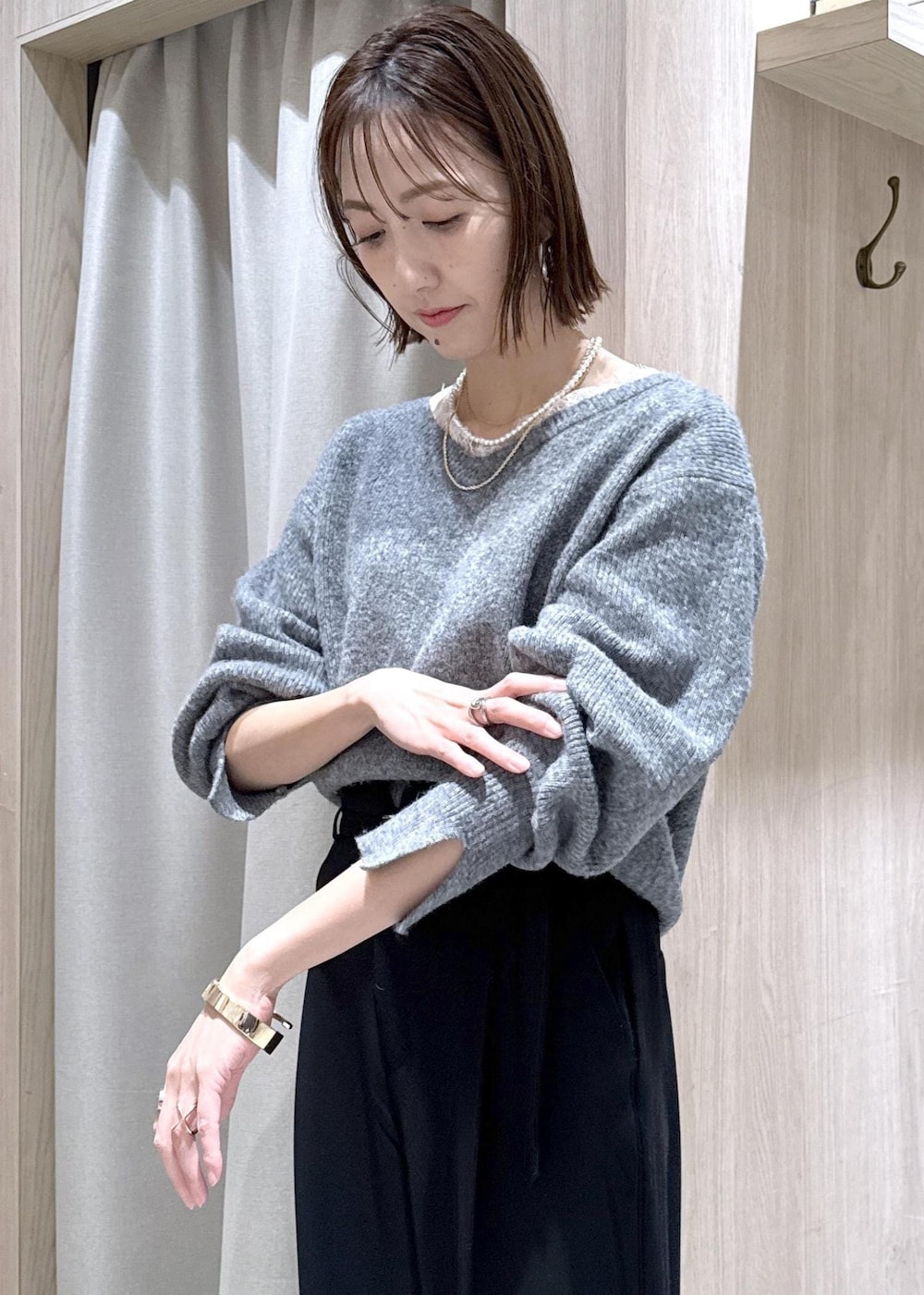 グレー系のニット/セーター、グレー系のその他アウター、ブラック系のその他パンツを着用したレディースの冬コーディネートの7枚目の写真