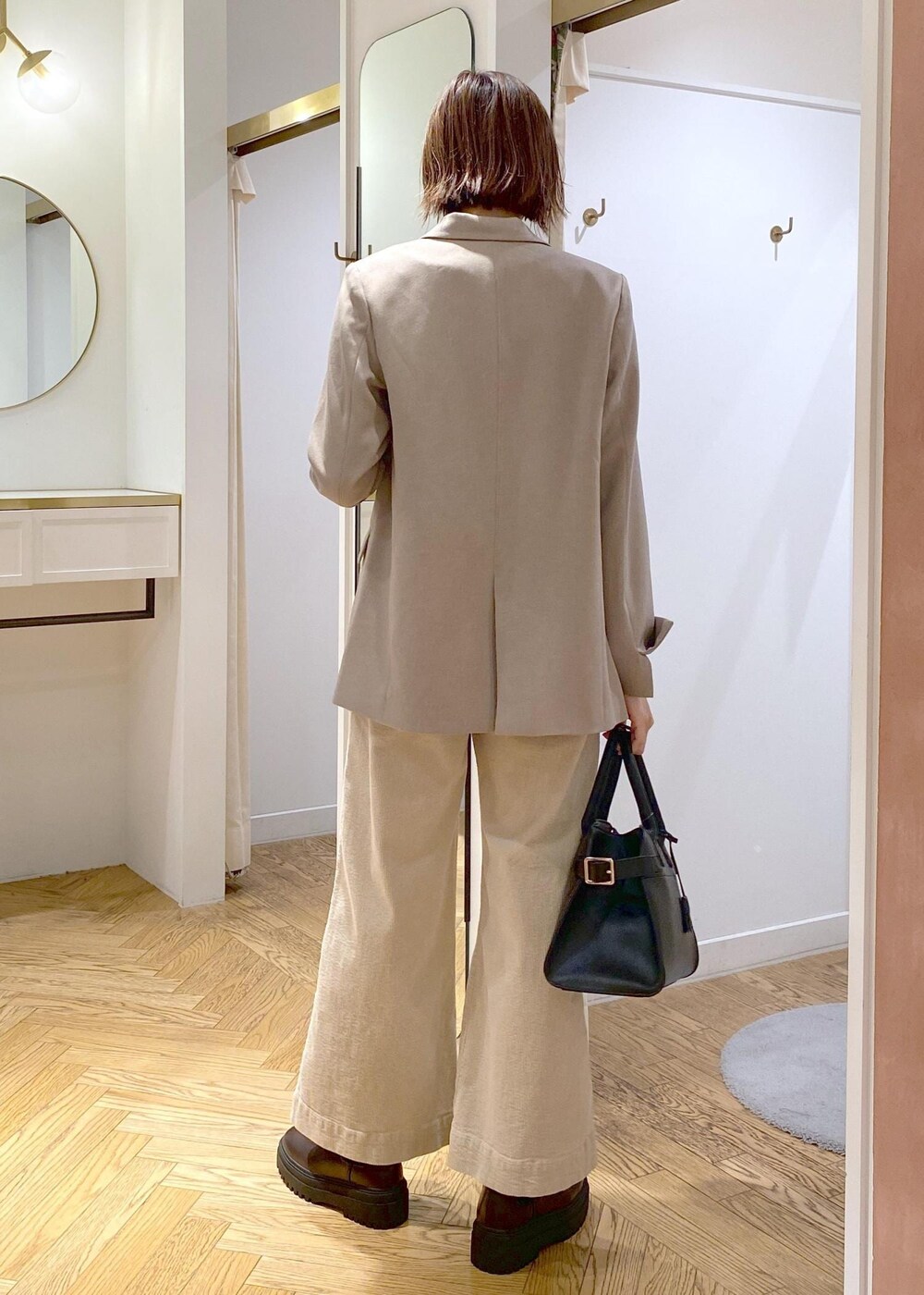 ブラック系のトートバッグ、ブラウン系のブーツ、ブラック系のTシャツ/カットソーを着用したレディースの秋コーディネートの3枚目の写真