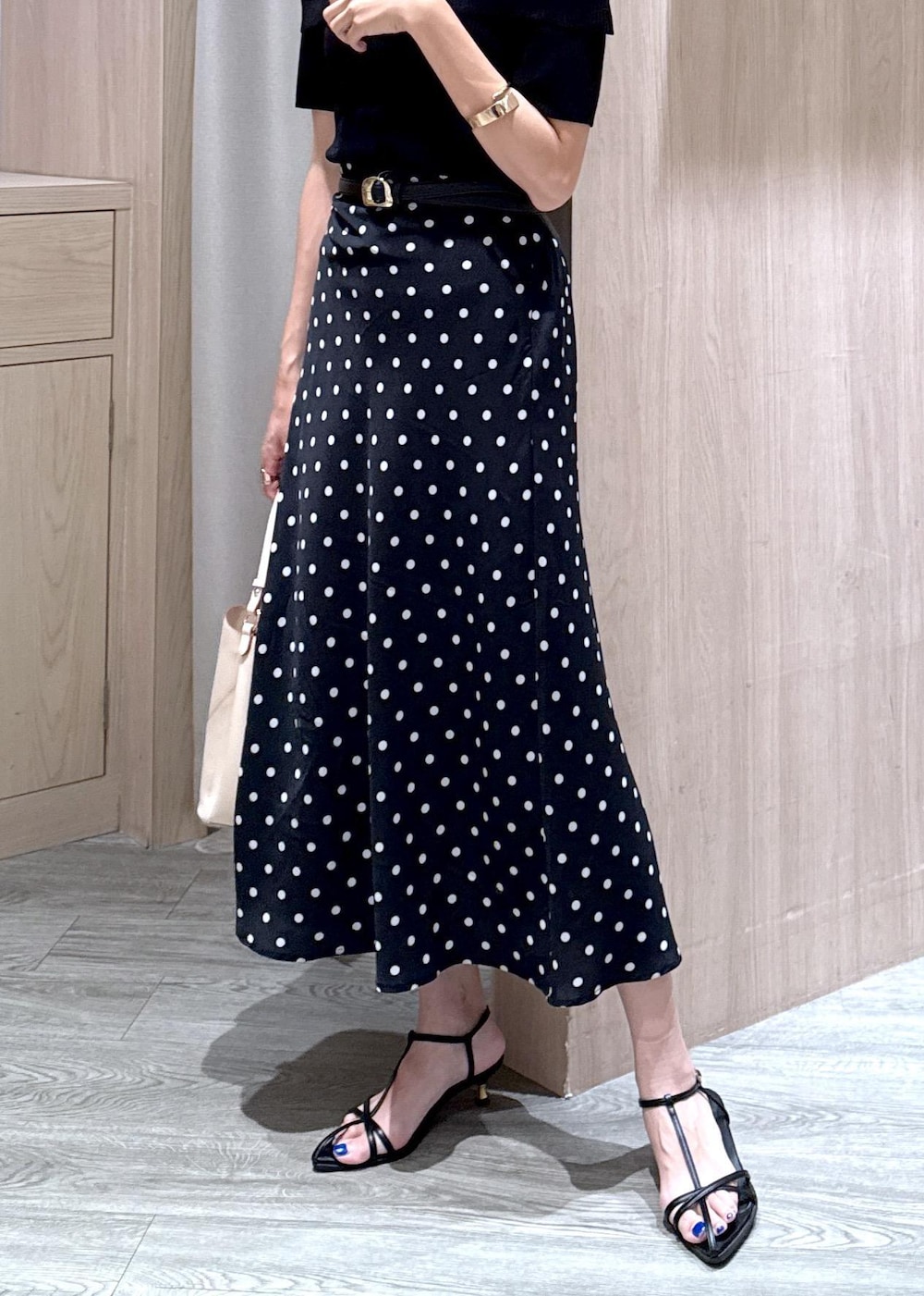 ベージュ系のショルダーバッグ、ブラック系のサンダル、ブラック系のスカートを着用したレディースの夏コーディネートの6枚目の写真