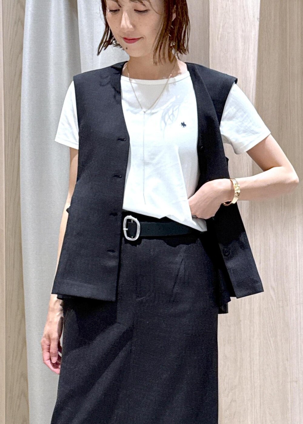 ブラック系のサンダル、グレー系のスカート、ホワイト系のTシャツ/カットソーを着用したレディースの夏コーディネートの8枚目の写真