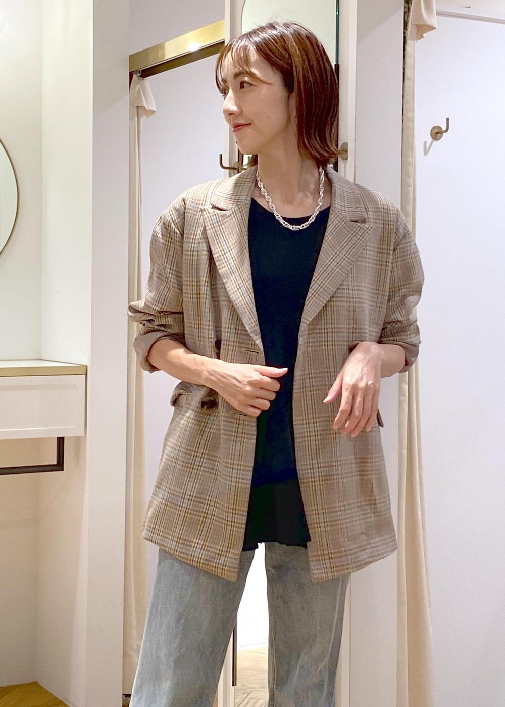 ブラック系のブーツ、ブラック系のTシャツ/カットソー、ブルー系のデニムパンツを着用したレディースの秋コーディネートの5枚目の写真