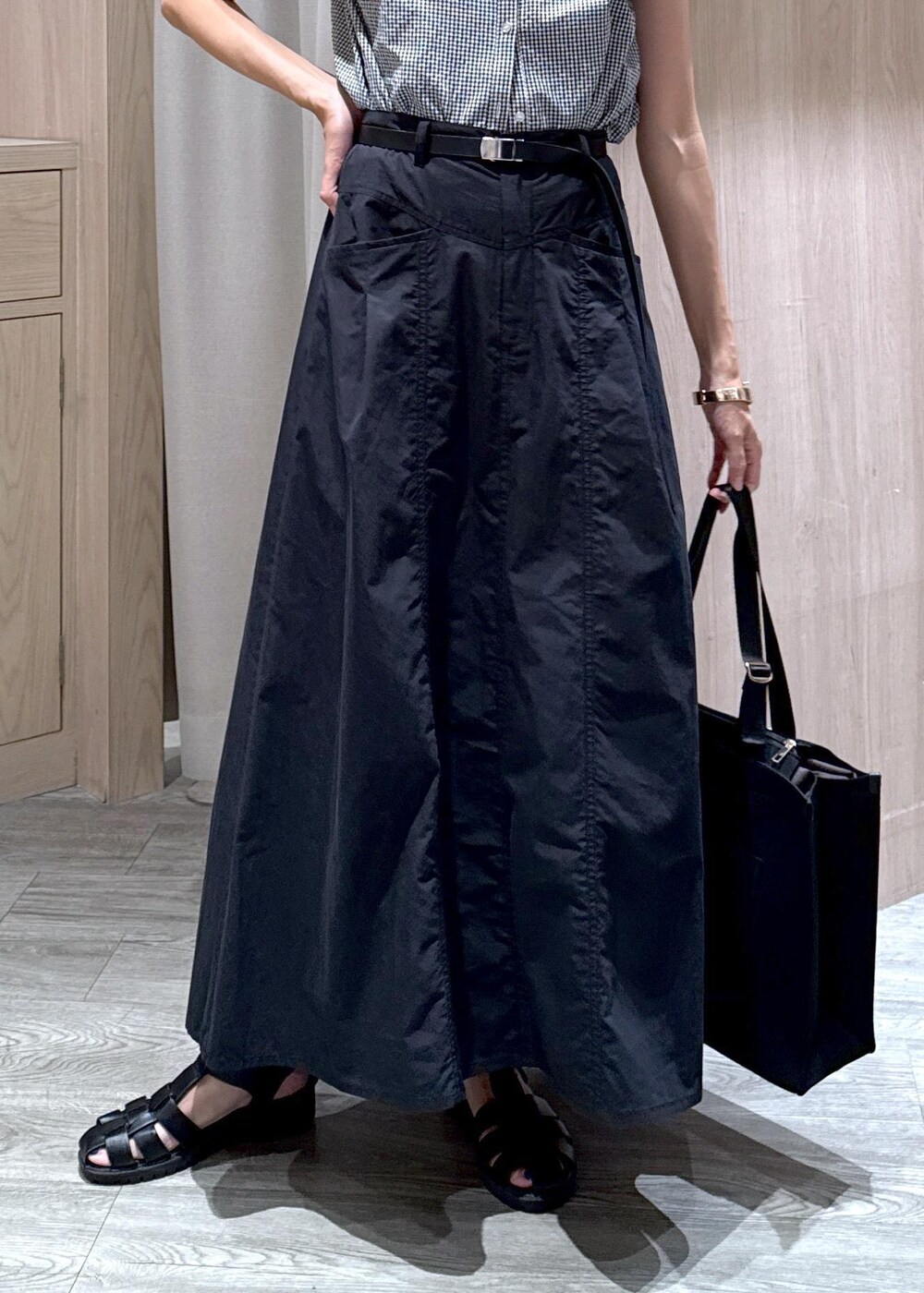 ブラック系のシャツ/ブラウス、ブラック系のトートバッグ、ブラック系のスカートを着用したレディースの夏コーディネートの7枚目の写真