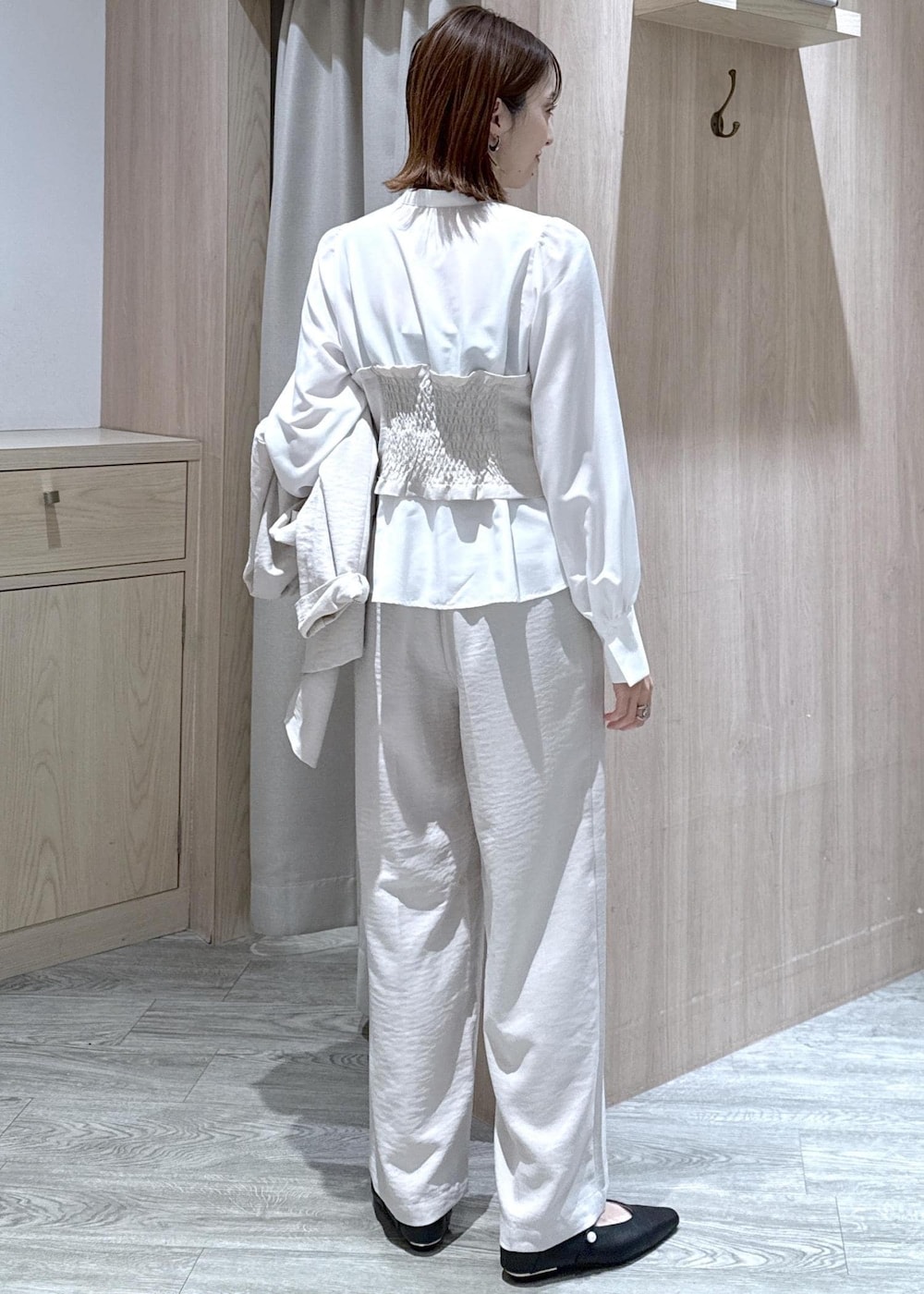 ブラック系のショルダーバッグ、ブラック系のパンプス、ホワイト系のシャツ/ブラウスを着用したレディースの春コーディネートの8枚目の写真