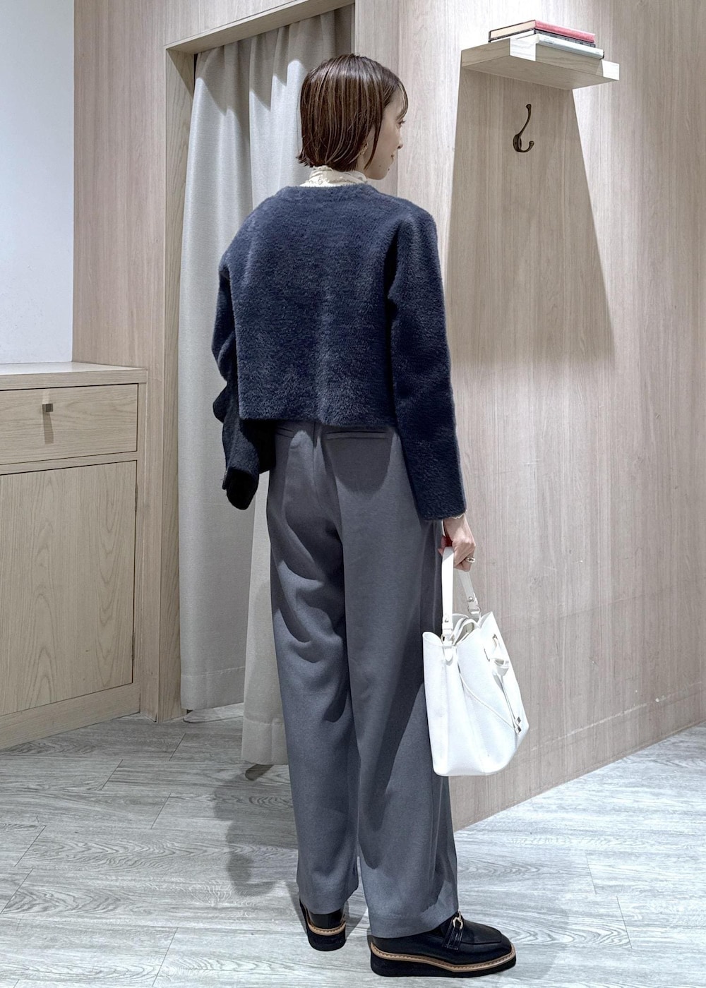 ホワイト系のショルダーバッグ、ブラック系のローファー、ブルー系のカーディガン/ボレロを着用したレディースの冬コーディネートの3枚目の写真