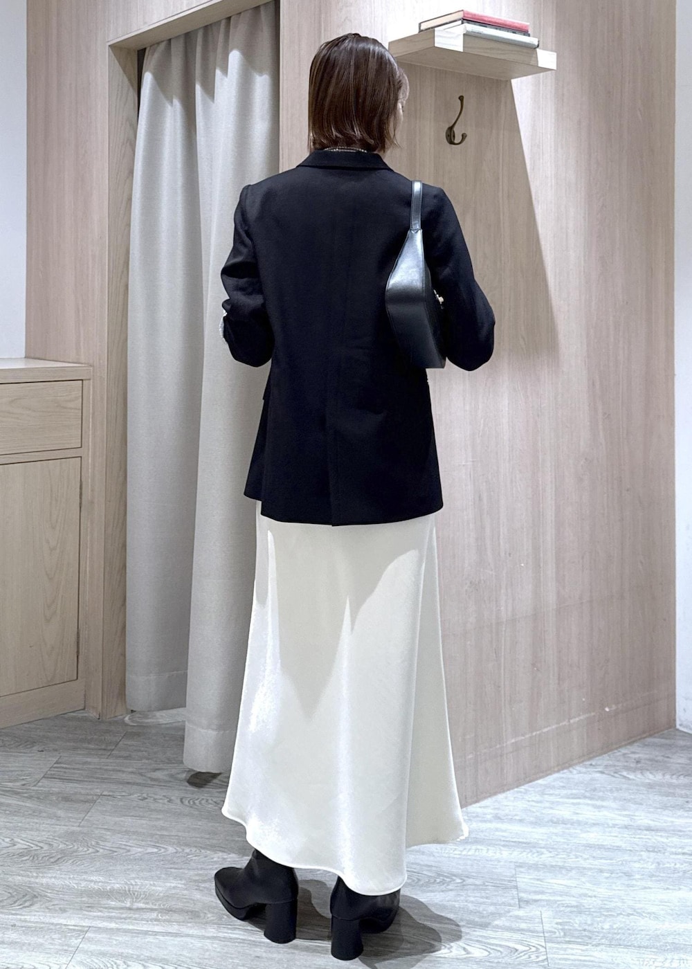 ブラック系のショルダーバッグ、ブラック系のテーラードジャケット、ブラック系のブーツを着用したレディースの冬コーディネートの3枚目の写真