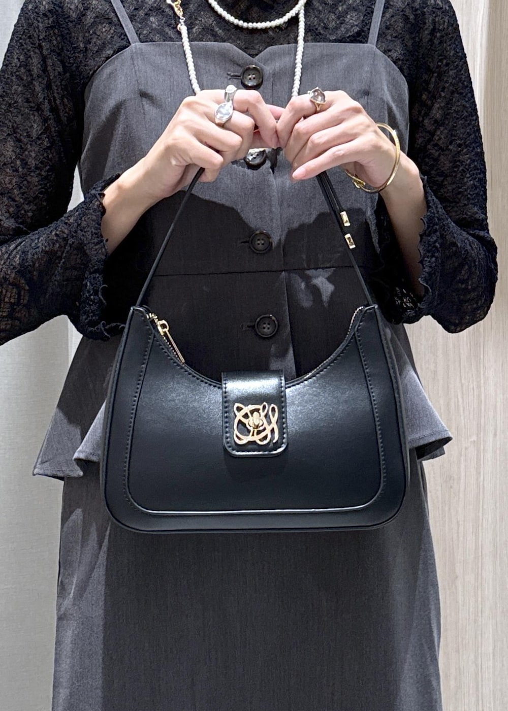 ブラック系のハンドバッグ、ブラック系のキャミソール、ブラック系のパンプスを着用したレディースの秋コーディネートの6枚目の写真