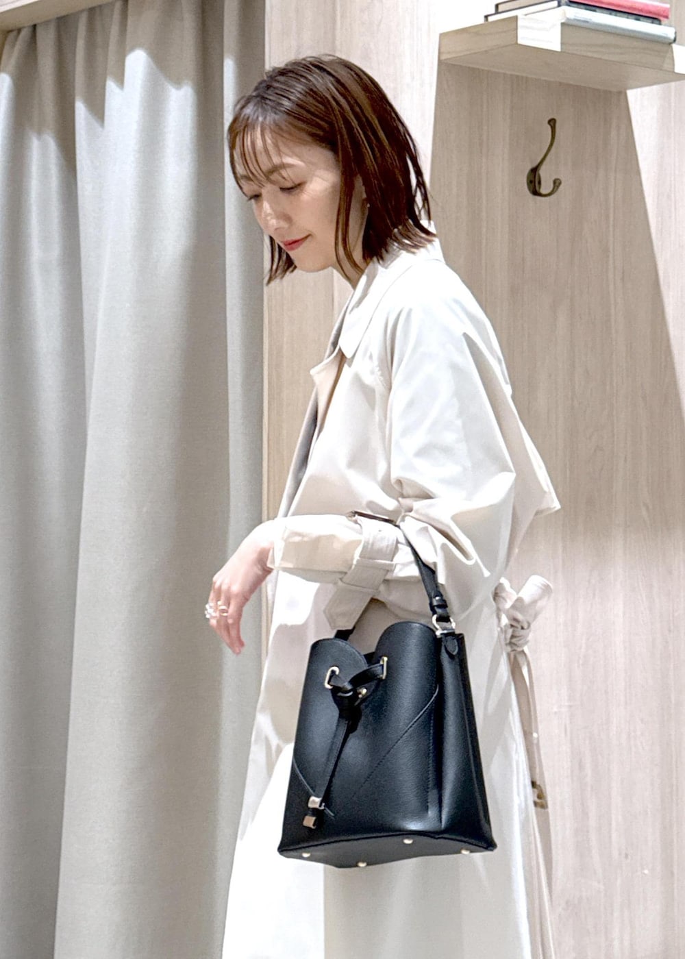 ブラック系のショルダーバッグ、ブラウン系のパンプス、ブルー系のデニムスカートを着用したレディースの春コーディネートの7枚目の写真