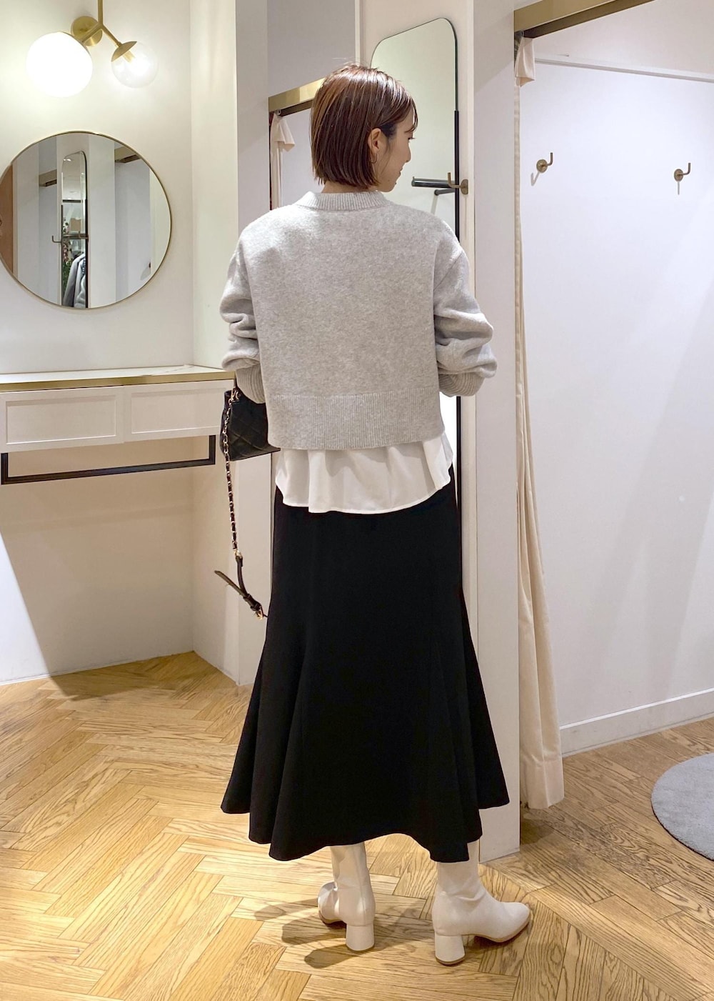 ホワイト系のシャツ/ブラウス、グレー系のカーディガン/ボレロ、ホワイト系のブーツを着用したレディースの冬コーディネートの3枚目の写真