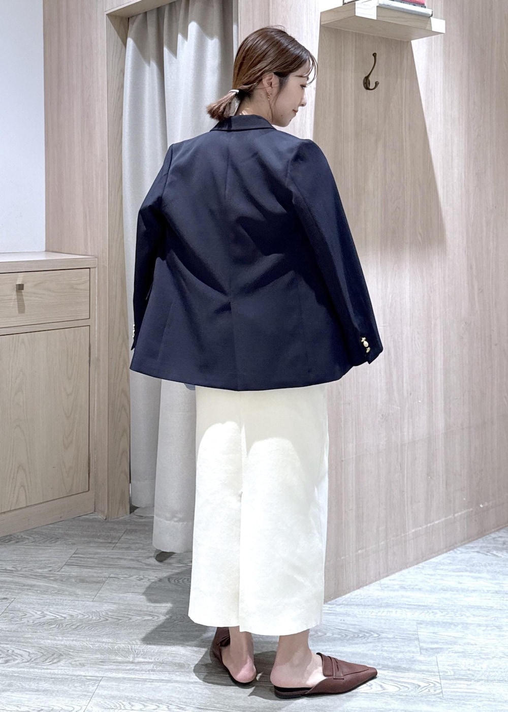 ブルー系のテーラードジャケット、ホワイト系のスカート、ブルー系のショルダーバッグを着用したレディースの春コーディネートの3枚目の写真