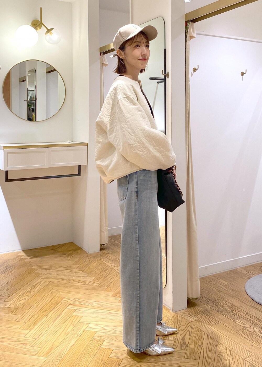 シルバー系のパンプス、ホワイト系のブルゾン、ブルー系のニット/セーターを着用したレディースの秋コーディネートの2枚目の写真