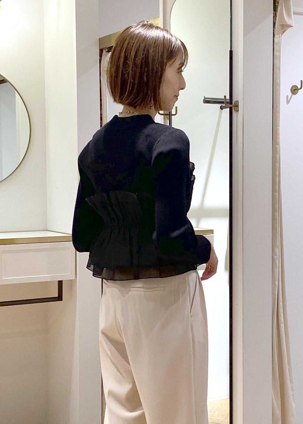 ブラック系のパンプス、ブラック系のニット/セーター、ベージュ系のその他パンツを着用したレディースの冬コーディネートの8枚目の写真